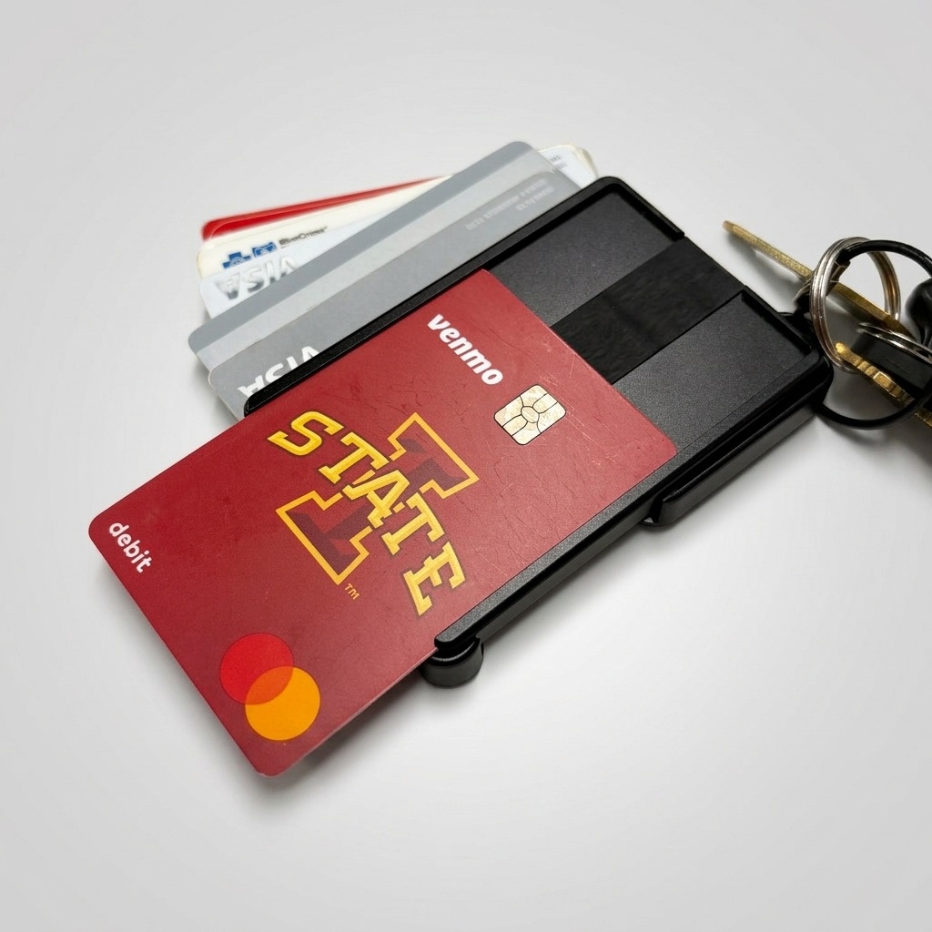 The Brik metal wallet with ID, cards, cash, and keys attached